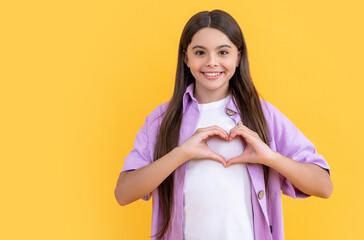 photo of teenager girl with love heart wearing shirt. teenager girl isolated on yellow.