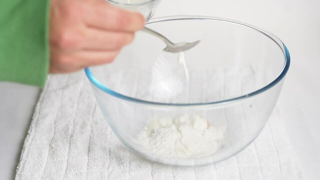 In a transparent bowl with eggs, I pour a tablespoon of milk to prepare the dough. High quality 4k footage