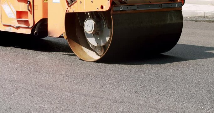 Road building asphalt paver is laying a new layer of asphalt, Road rollers drive on a new road. Asphalt paver machine on a road construction site.