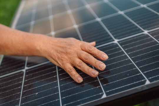 Senior Engineer Is Checking With Tablet An Operation Of Sun And Cleanliness On Field Of Photovoltaic Solar Panels On A Sunset. Renewable Energy, Technology, Electricity, Service Concept 