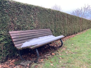 Der letzte Schnee taut auf einer Bank im Park