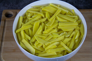 Sliced potatoes for pan frying. Yellow potatoes in a bowl