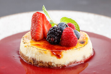 Homemade cheesecake with strawberries, blackberries, blueberries and mint leaves. Shallow depth of field