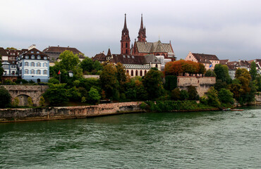 Fototapeta na wymiar View of the Gothic red brick Basel Cathedral and the embankment of the Rhein River in the city of Basel, northern Switzerland 