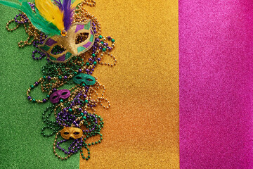 Mardi gras, Venetian or Carnivale mask on on a tricolor shining background.