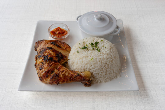 Paris, France - 01 18 2023: African dishe culinary Still Life. Chicken Yassa with Grilled chicken, rice accompaniement and spicy sauce