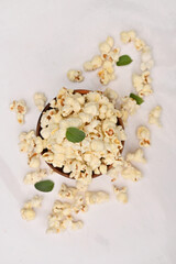 closeup the bunch white yellow popcorn with green mint leaves isolated on white background.
