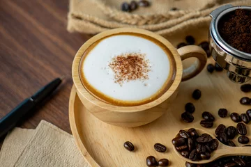 Fotobehang Hot coffee espresso latte with milk froth foam in wood cup. barista pouring milk liquid froth foam to wood cup of espresso for make creamy cappuccino hot drink. © BESTIMAGE