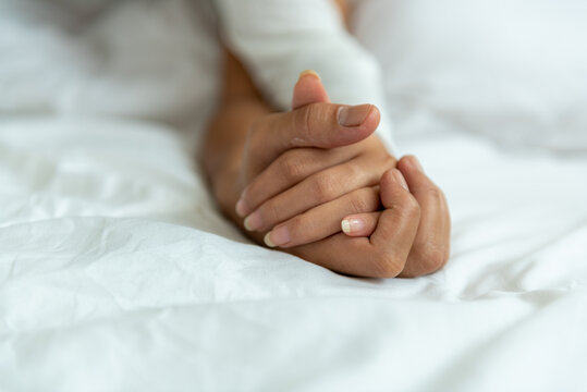lover married couple encourage clasp by holding hands on white bed. clasp encourage husband and wife together in love and happy relationship.