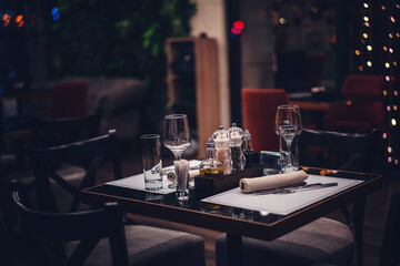 Table served for dinner in a cafe restaurant, with glasses, cutlery and spices