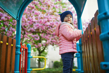 Happy 4 years old girl playing on a playground in Paris, France