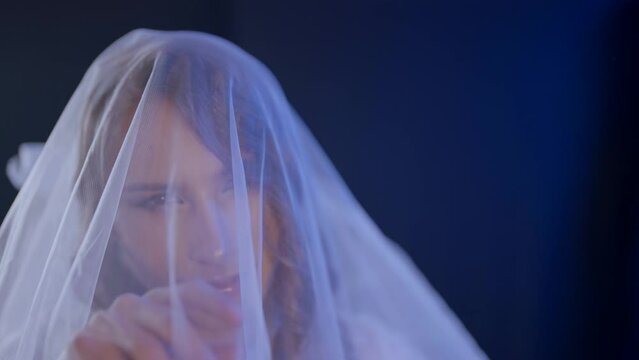 gay man in bridal gown, portrait of pretty homosexual guy with wedding white veil on face, closeup