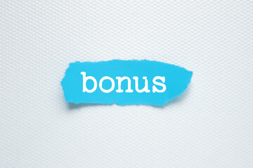 Writing text Bonus on blue torn paper