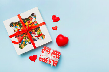 Valentine day composition: sweet candy, with gift boxes with bow and red felt hearts, photo template, background. Top View with copy space