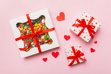 Valentine day composition: sweet candy, with gift boxes with bow and red felt hearts, photo...