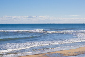 Fototapeta na wymiar Striking scene of waves breaking on the sand of a Spanish beach 