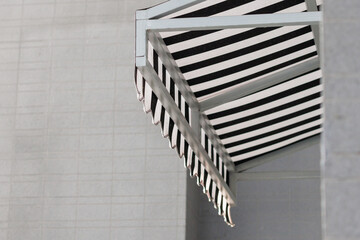 the black and white striped awning of the house canopy. exterior canvas roof. blind sun