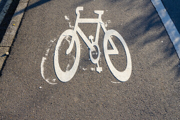 bicycle lane sign painted on a road