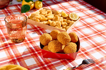 Typical Sicilian street food arancini (deep fried rice balls with meat) on paper plate take out. Unhealthy food.