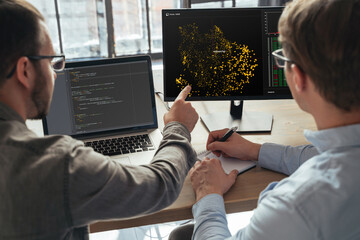 Closeup of two men data science specialists working at office together, analyzing big data on...