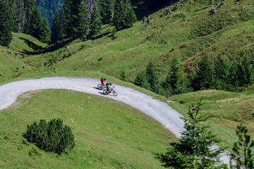 Zwei Mountainbiker beim Downhill auf einer Schotterpiste im Gebirge