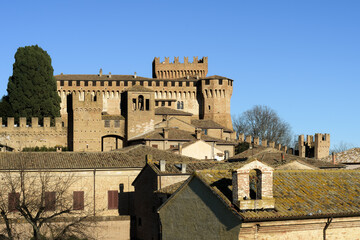 The castle of Gradara seen from afar with copy space in the sky. Gradara is a middle age italian village near Urbino famous for the stoy of Paul and Francesca in Dante Alighieri’s Divine Comedy - 566330057