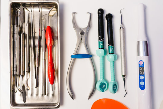 Dental set for treatment and filling of teeth. Dentist metal tools: corncang, curette, probe, gross-mayer clamp, dental mirror, explorer. Ultraviolet, uv lamp. Hygiene and healthcare concept. Top view