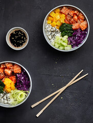two asian poke bowls with vegetables soy sauce and chopsticks