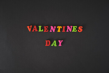 Text Valentines day by colorful letters on black background.