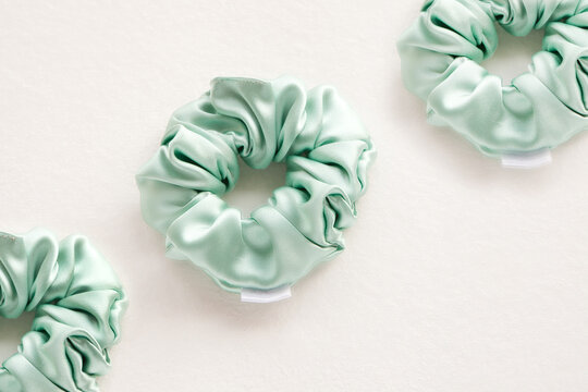 turquoise silk scrunchy flat lay on white. Hairdressing tools for ladyes. Pastel Elastic Hair tie