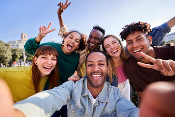 Happy multiethnic group of friends taking a selfie outdoors, having fun in sunny day. University...