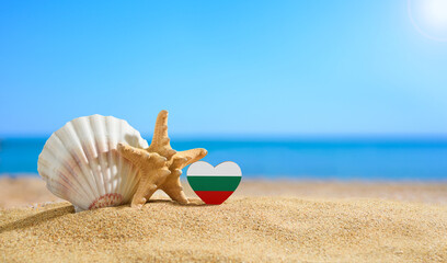 Beautiful beach in Bulgaria. Flag of Bulgaria in the shape of a heart and shells on a sandy beach.