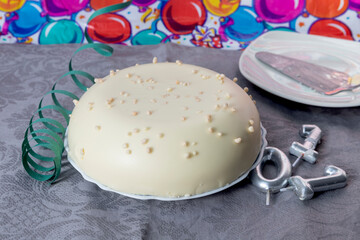 White chocolate cake for birthday with number candles and background with balloons for party