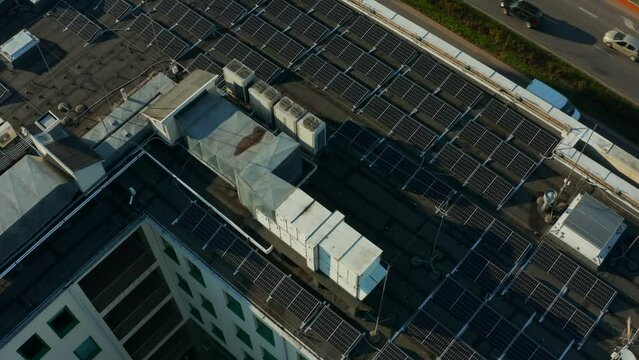 Aerial view of many solar panels installed on the roof of an apartment building. Solar panels at the top of the building. Solar modules on a flat roof.
