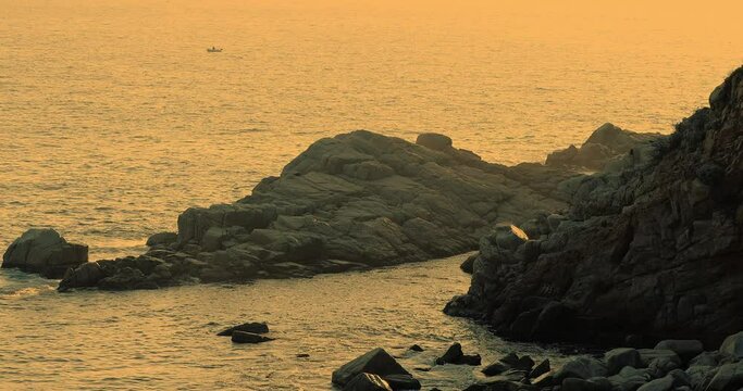 Cinematic video of the Mediterranean Sea on the Costa Brava during a sunset. Cliffs in Nature