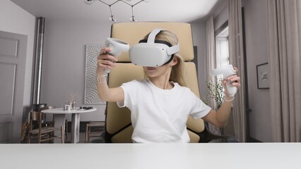 Girl wearing a virtual reality glasses having fun playing online video games in room