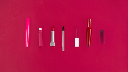 Flat lay beauty and fashion with lipsticks, powder lip gloss brushes on Magenta background Essential beauty items Beauty Cosmetics Fashion