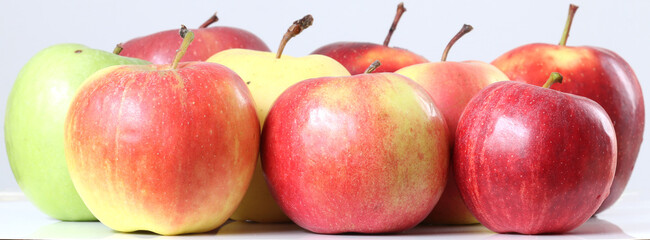Apples of different varieties. Apples on a light background.