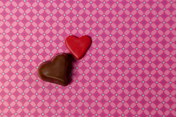 Chocolates en forma de corazón en fondo de patrón lila, concepto del día mundial del amor y la amistad, san Valentín.