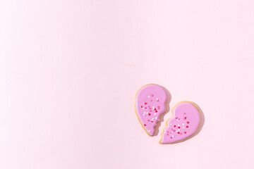 Broken heart concept. Divorse, quarrel. significant other. broken cookie in heart shape on pink background. Family psychotherapist, break, loss concept. St. Valentine's Day. two parts. Copy space