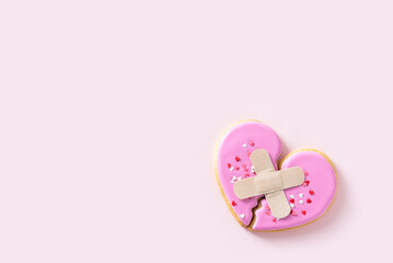 Unrequited love concept. Broken heart, breakup, separation, divorce, significant other concept. Two plastered halves of one heart on a pink background. Conflict, heart desease, depression, loneliness