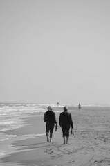 old people walking on the beach