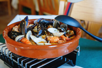 Traditional Spanish seafood zarzuela - stewed fish fillets, sea molluscs and crustaceans in thick...