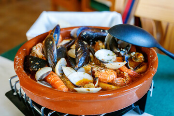 Traditional Spanish seafood zarzuela - stewed fish fillets, sea molluscs and crustaceans in thick...