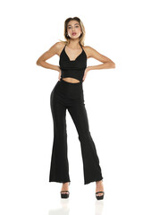 a young woman in black wide trousers and bra posing on a white background