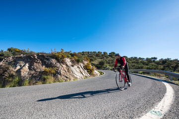 Cyclist ride a red bicycle on the road of the mountain during the morning