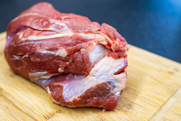 raw beef shoulder on a cutting board. Meat to be boiled in tradional italian dish "bollito". Raw meat to be sealed and roped for boiling or roast