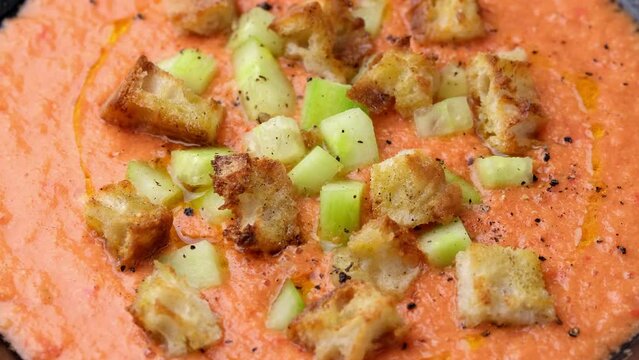 Traditional spanish Gazpacho soup with tomatoes, vegetables and croutons. Rotating video