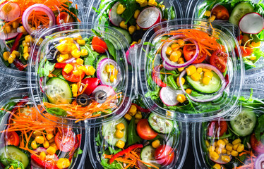 Boxes with pre-packaged vegetable salads in a commercial fridge