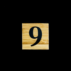 number 9 nine wooden isolated on black background.